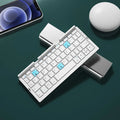 Silver white foldable Bluetooth keyboard open with tablet on stand and closed for pocket storage