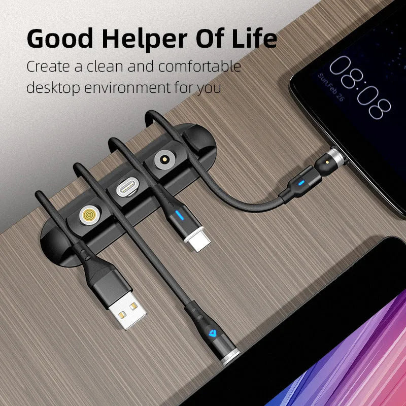 Black soft plastic magnetic desktop charging cable organiser stand on a desk.