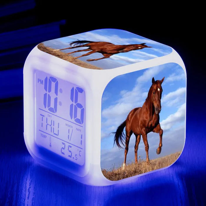 Square cartoon-style LED alarm clock with colour-changing display showing digital time and temperature