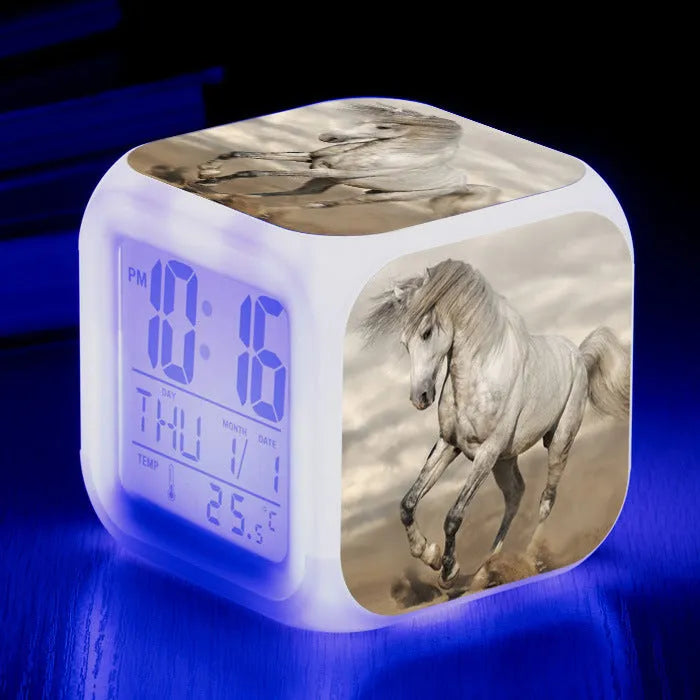 Square cartoon-style LED alarm clock with colour-changing display showing digital time and temperature