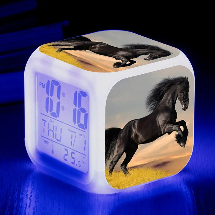 Square cartoon-style LED alarm clock with colour-changing display showing digital time and temperature