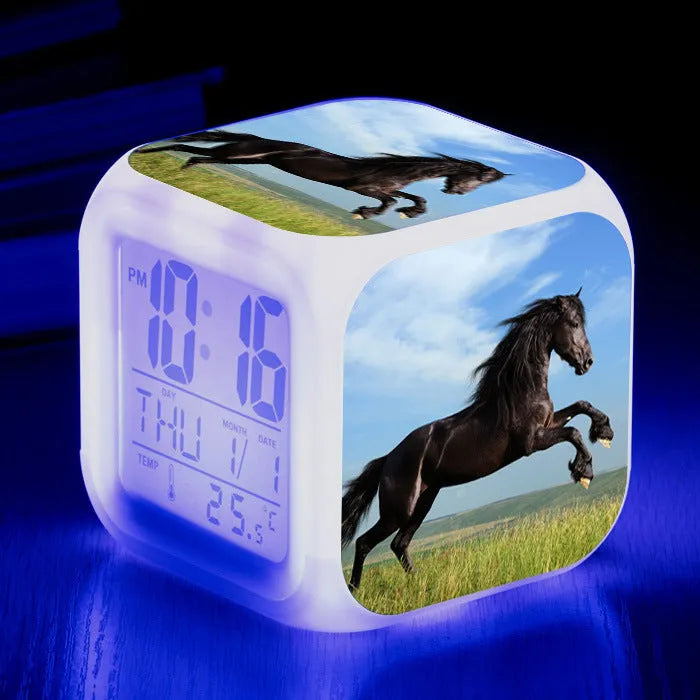 Square cartoon-style LED alarm clock with colour-changing display showing digital time and temperature