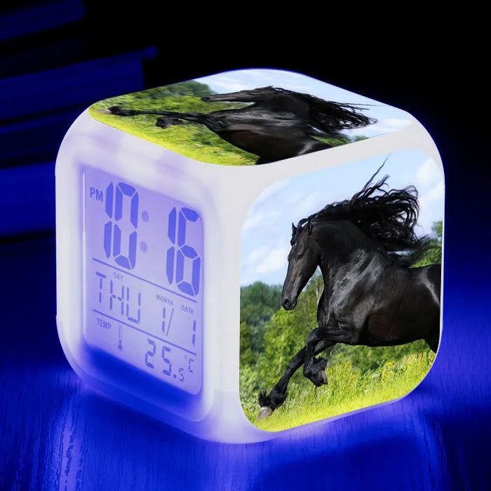 Square cartoon-style LED alarm clock with colour-changing display showing digital time and temperature