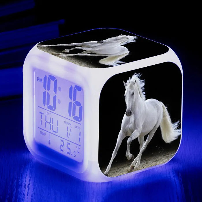 Square cartoon-style LED alarm clock with colour-changing display showing digital time and temperature