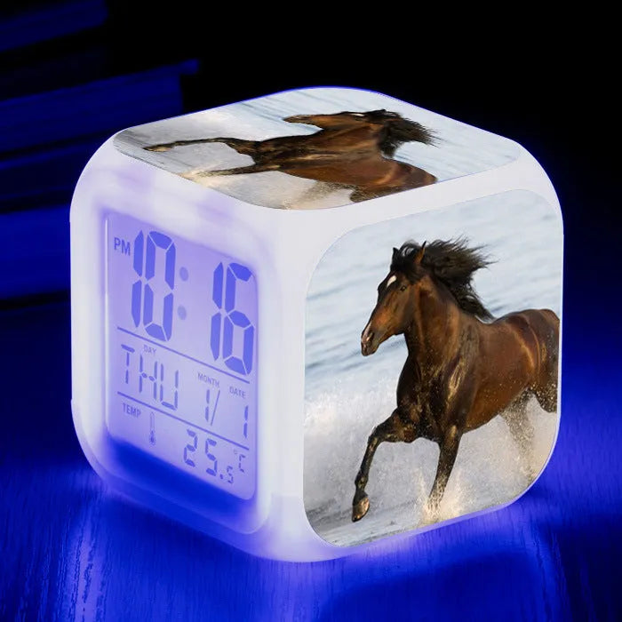 Square cartoon-style LED alarm clock with colour-changing display showing digital time and temperature