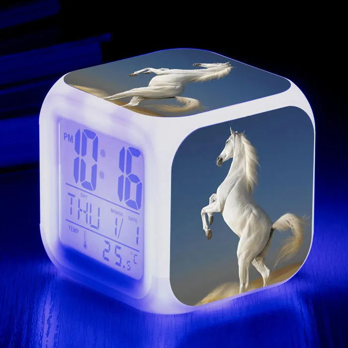 Square cartoon-style LED alarm clock with colour-changing display showing digital time and temperature