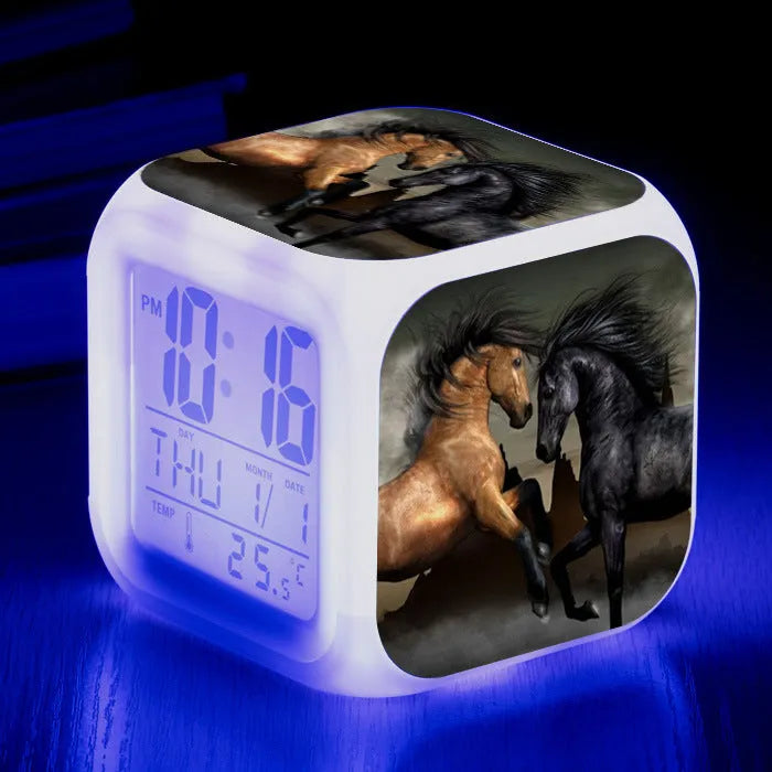 Square cartoon-style LED alarm clock with colour-changing display showing digital time and temperature