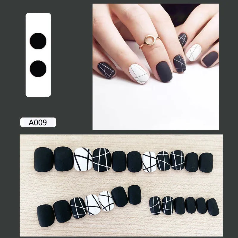 Fake nail patch with matte black and white lines design on a white background
