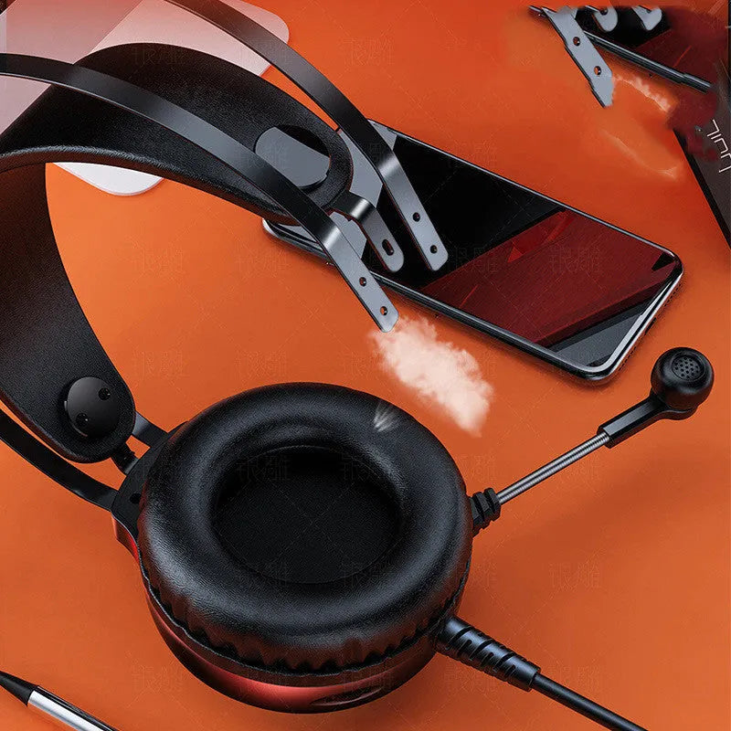 Black wired over-ear computer headset with microphone and 3.5mm plug on a desk.