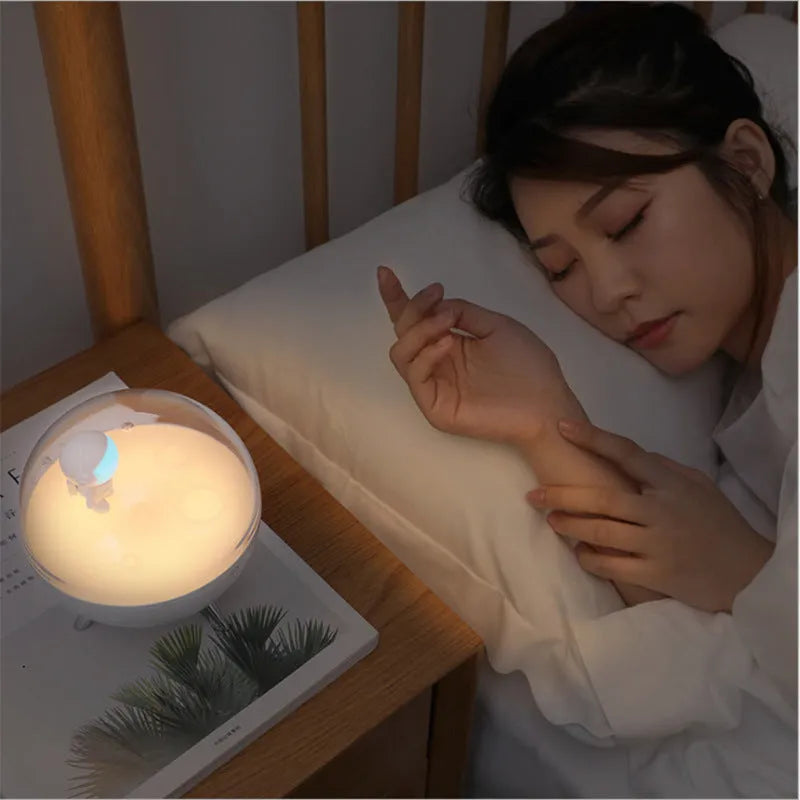 Modern cartoon-style USB LED desk lamp on a bedside table, showing white light option.