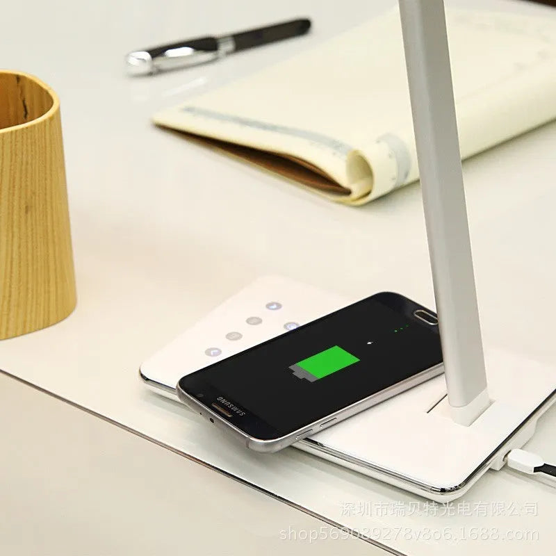 Black and white wireless charging desk lamp with touch controls and aluminium shade.