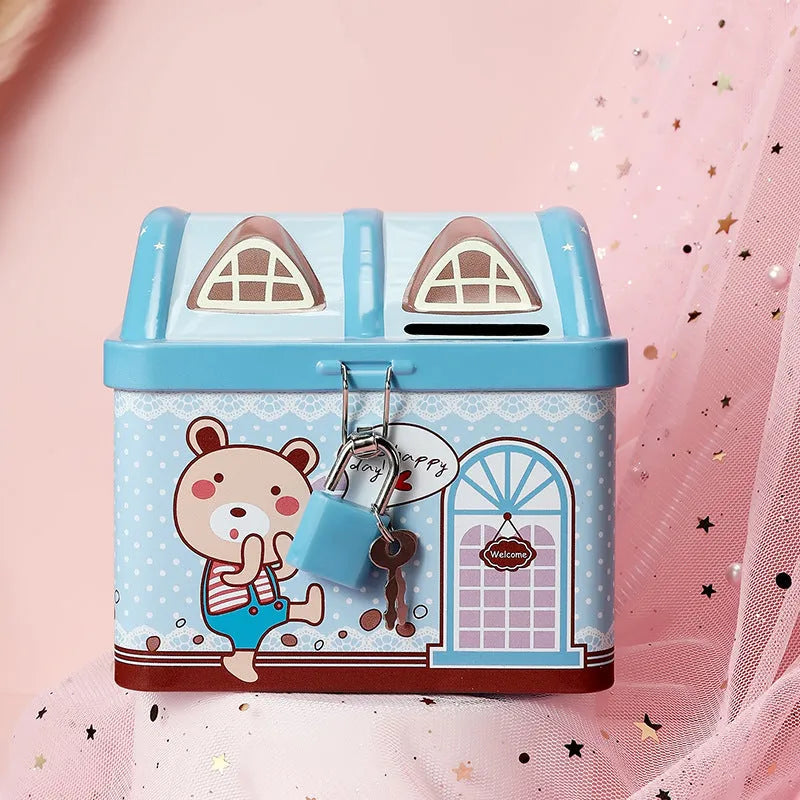Blue tinplate house-shaped piggy bank with coin slot lid on wooden desk