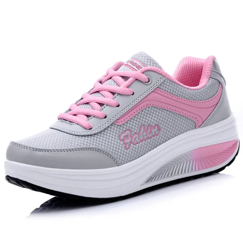 Women's grey knit slip-on travel shoes with elasticated side and medium heel on a plain background.