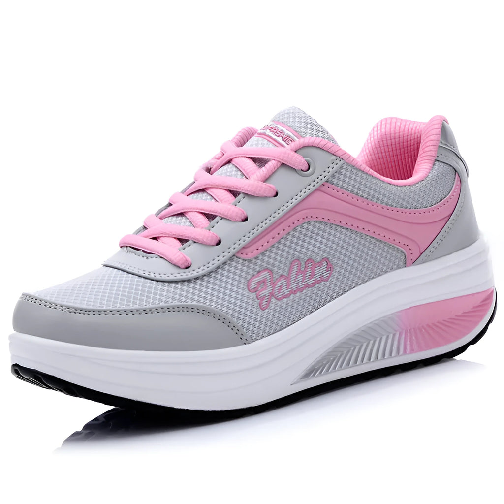 Women's grey knit slip-on travel shoes with elasticated side and medium heel on a plain background.