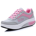 Women's grey knit slip-on travel shoes with elasticated side and medium heel on a plain background.