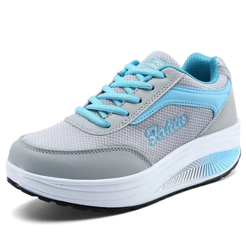 Women's grey knit slip-on travel shoes with elasticated side and medium heel on a plain background.