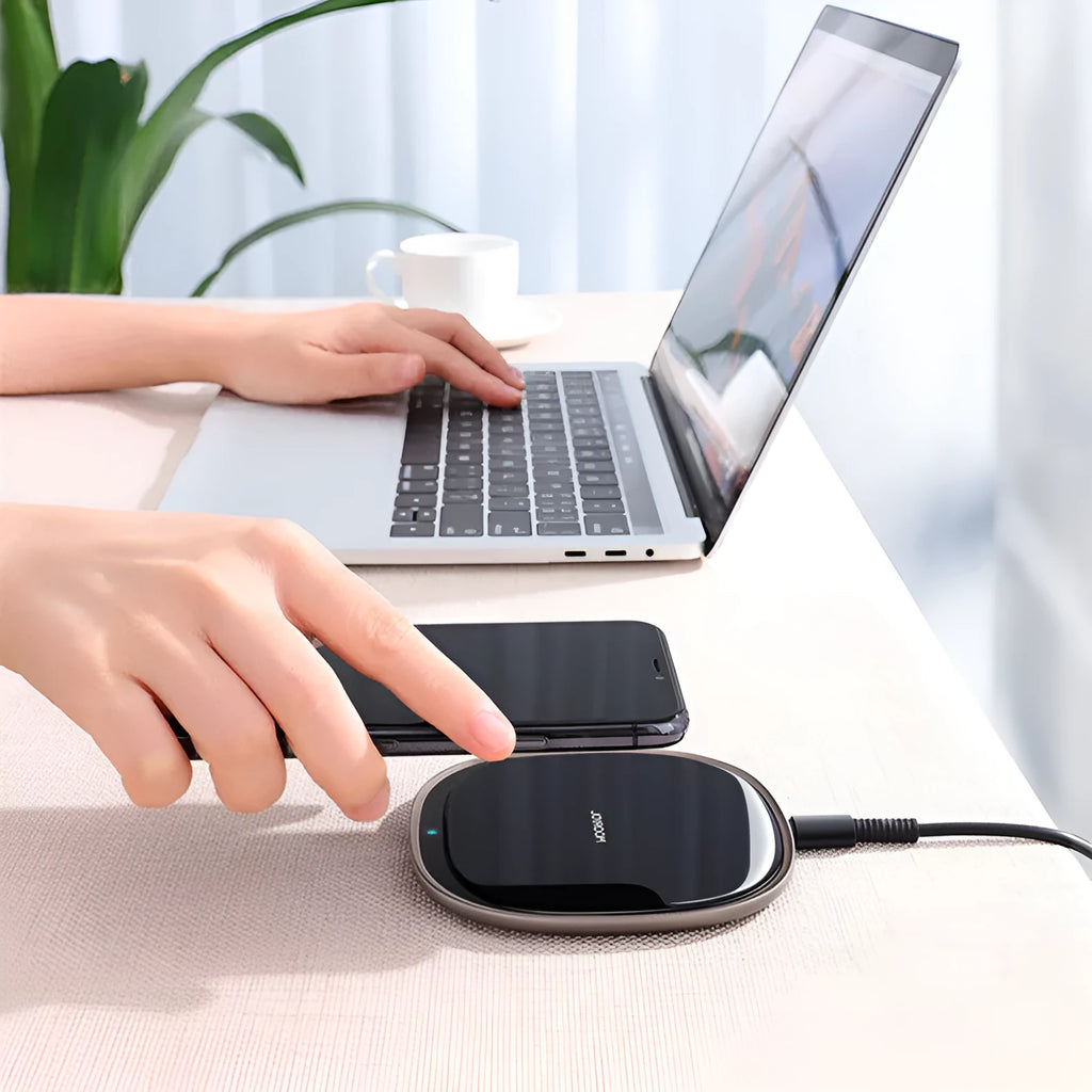 Black 15W wireless phone charger with glass top and zinc alloy body on a desk