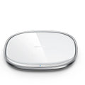 Black 15W wireless phone charger with glass top and zinc alloy body on a desk