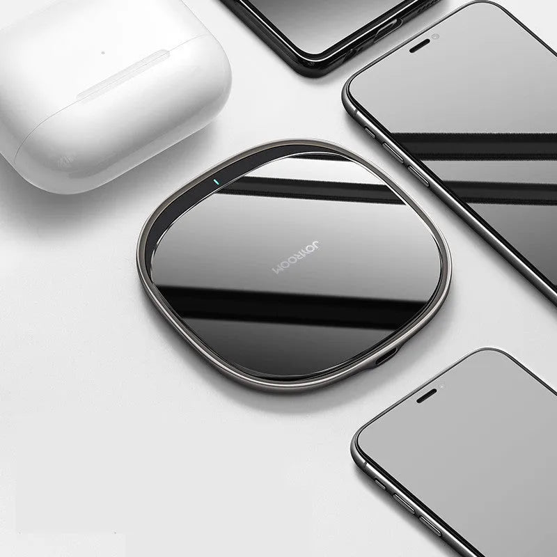 Black 15W wireless phone charger with glass top and zinc alloy body on a desk