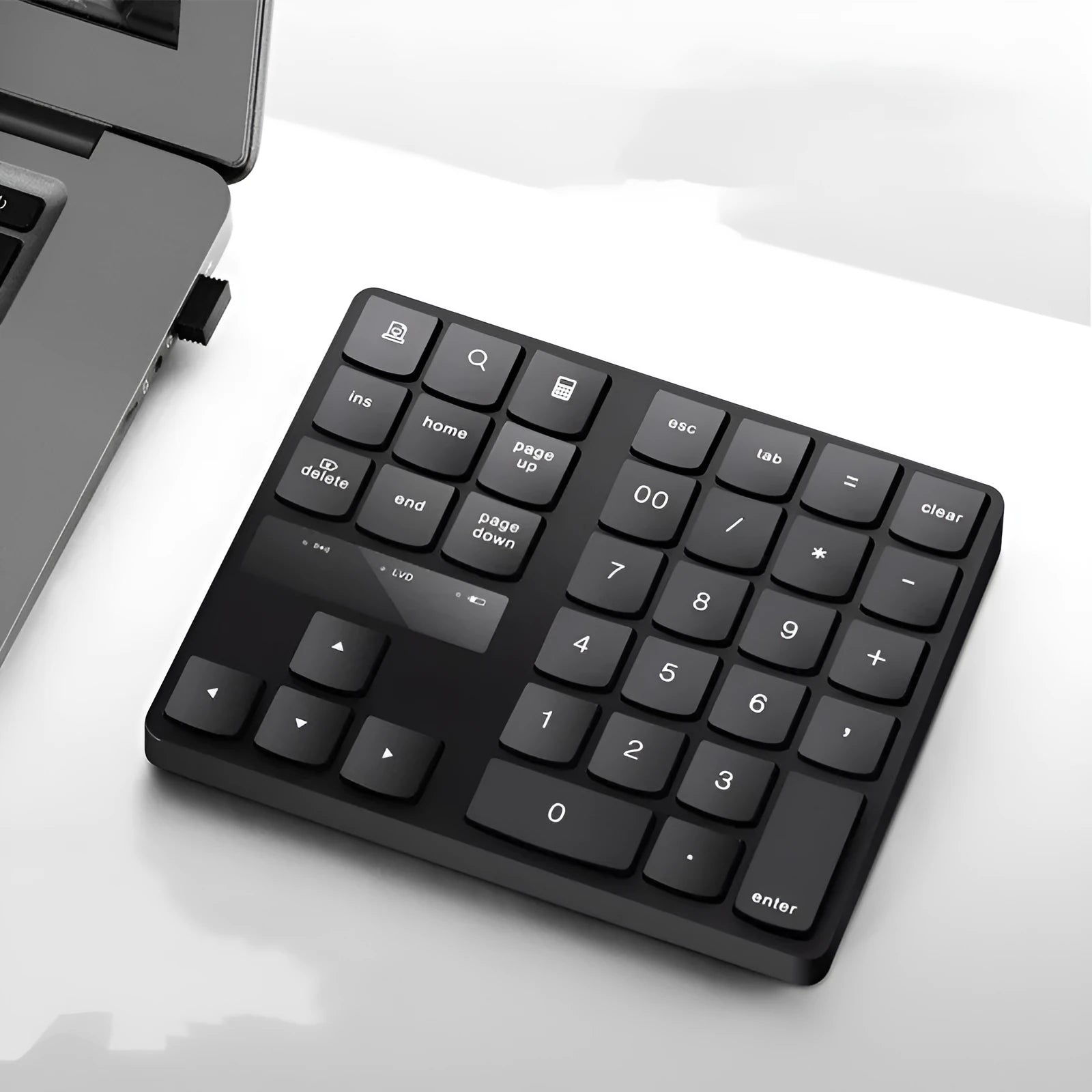 Black wireless 35-key numeric keyboard with USB receiver and charging cable on desk