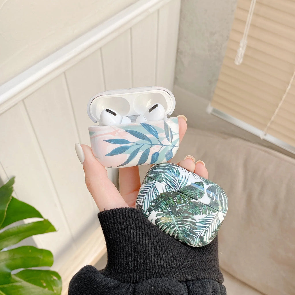Blue soft TPU AirPods case with painted tropical banana leaves design.