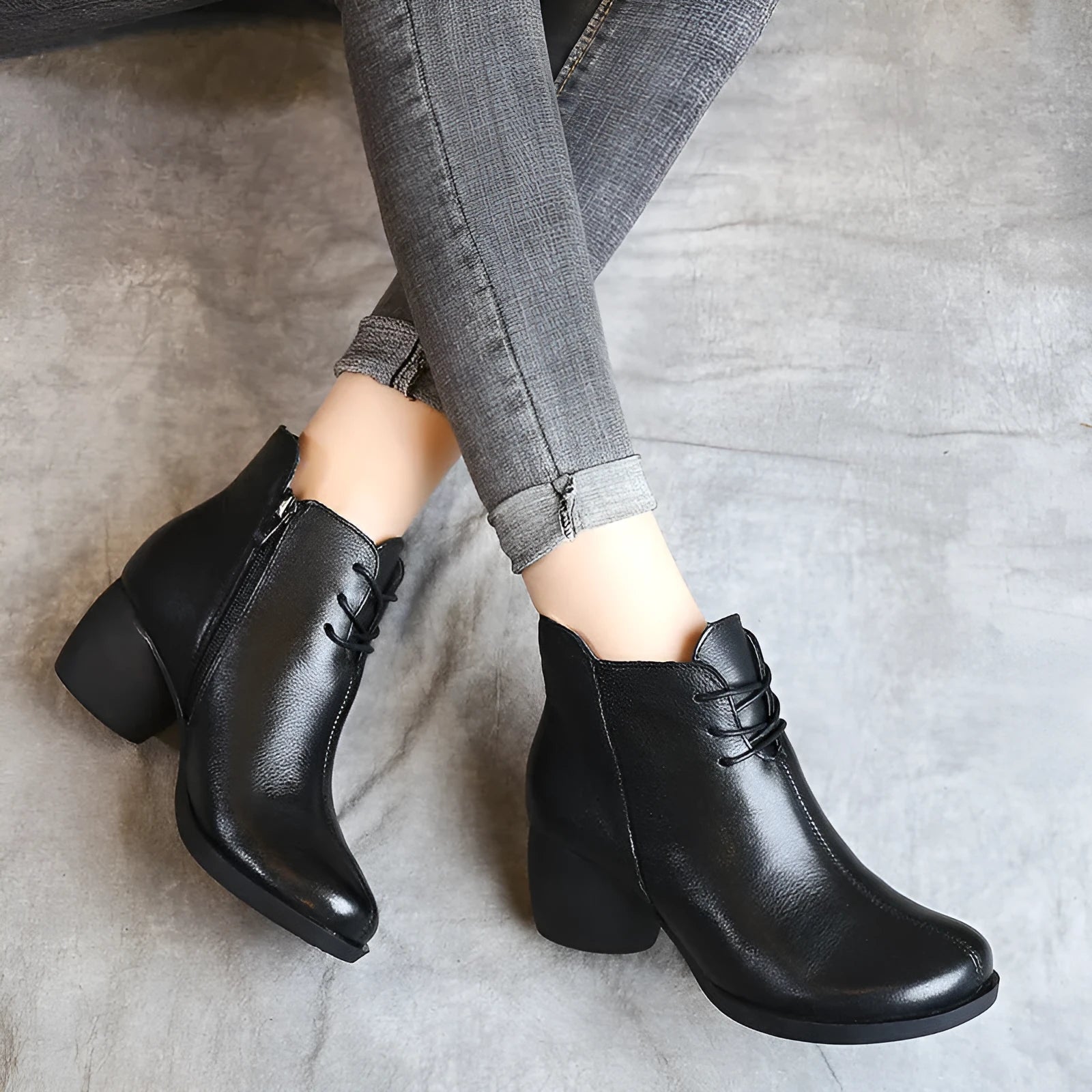Women's black leather Martin boots with a thick mid heel and round toe on a light background.