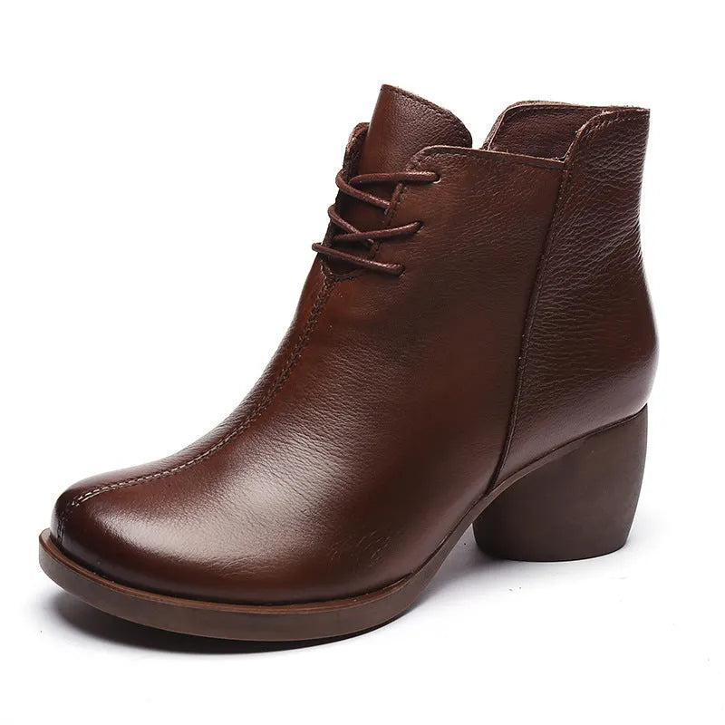 Women's black leather Martin boots with a thick mid heel and round toe on a light background.