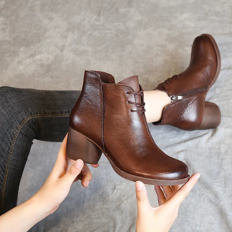 Women's black leather Martin boots with a thick mid heel and round toe on a light background.