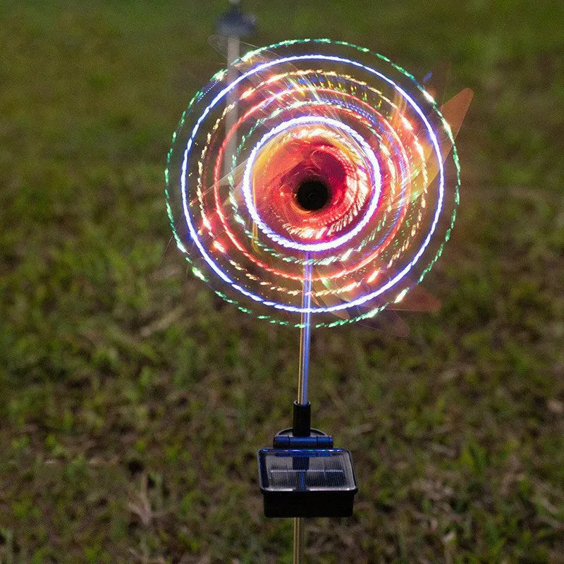 Solar wind spinner light with LED illumination spinning on lawn at dusk, showing IP65 waterproof aluminium and ABS construction