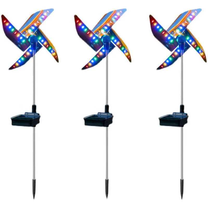 Solar wind spinner light with LED illumination spinning on lawn at dusk, showing IP65 waterproof aluminium and ABS construction