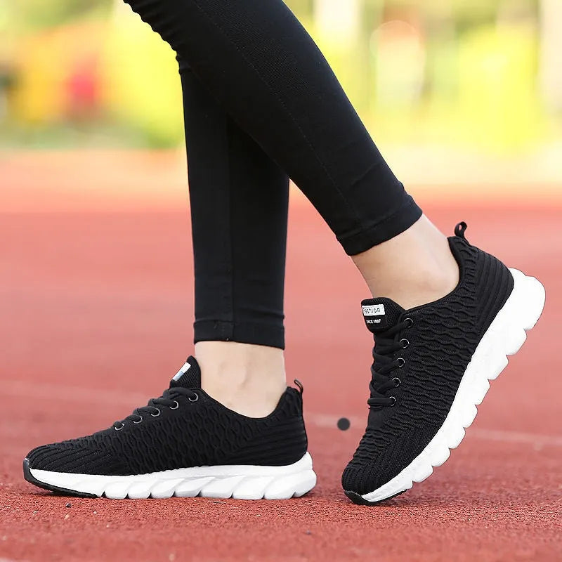 Women's running shoes with fly weave upper in black, pink, or white, showing wear-resistant outsole.