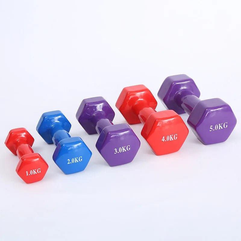 A set of bright green and pink plastic fitness dumbbells on a wooden floor.