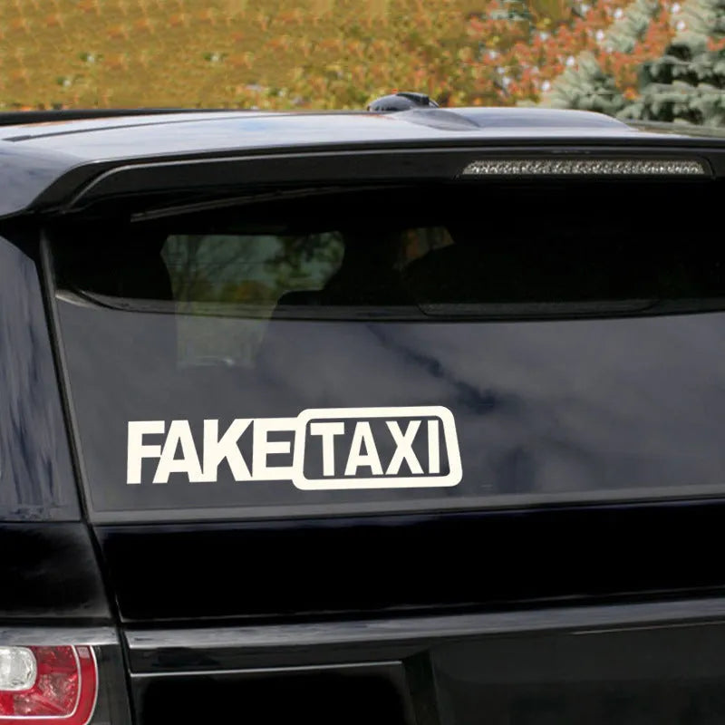 Black Fake Taxi car window sticker on glass, showing waterproof PET material and 20cm by 8cm size.