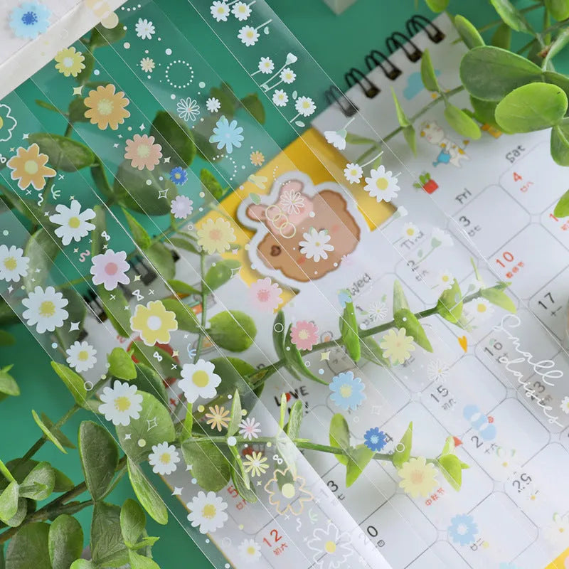 Five rolls of transparent adhesive tape with colourful daisy decoration on clear PET polyester backing