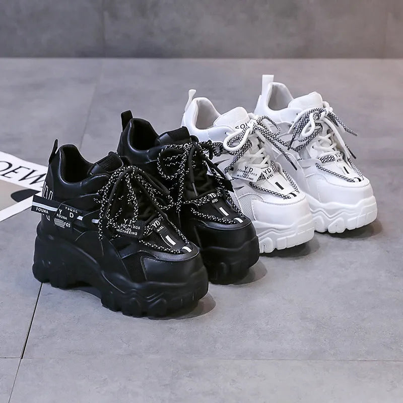 Women's white low-top platform tennis shoes with mesh upper and cross-strap detail on a rubber sole.