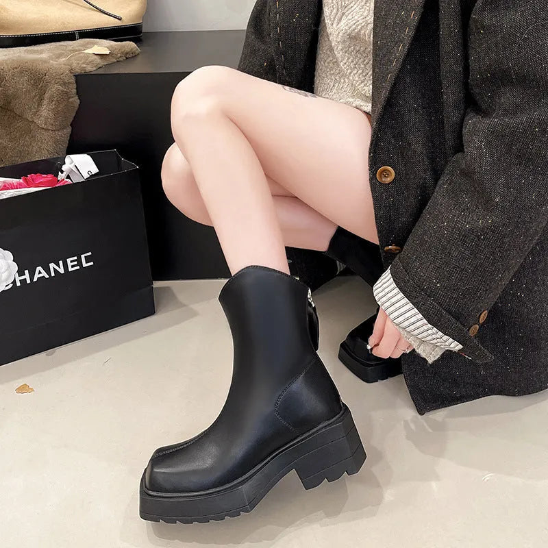 Women's black square-toe platform Martin boots with a block heel and rear zip on a white background
