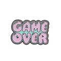 Stereo game console badge made from alloy, shown in one of three colour options with independent OPP packaging.