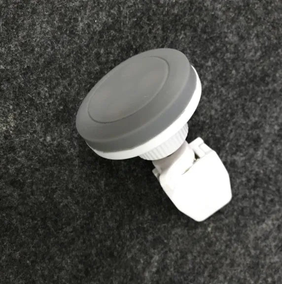 Black magnetic car phone holder mounted on vehicle dashboard with smartphone attached