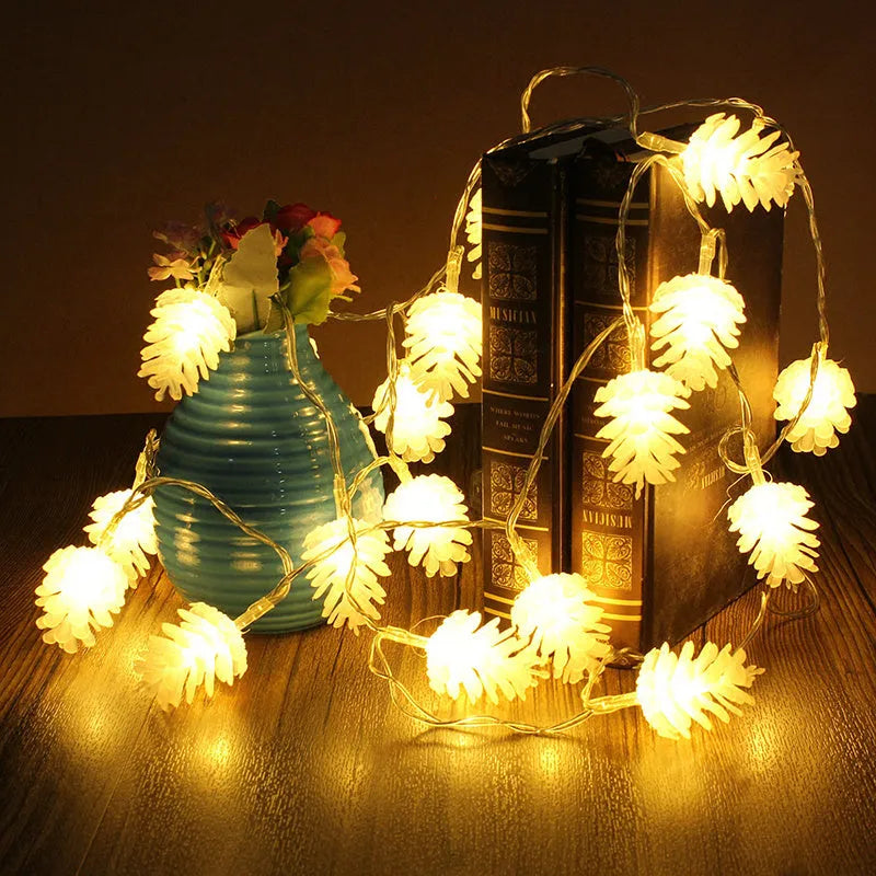 Battery-powered warm white LED pine cone fairy lights draped decoratively on a surface.