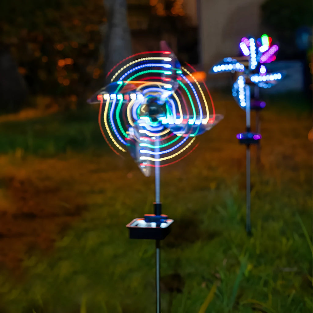 Solar wind spinner light with LED illumination spinning on lawn at dusk, showing IP65 waterproof aluminium and ABS construction