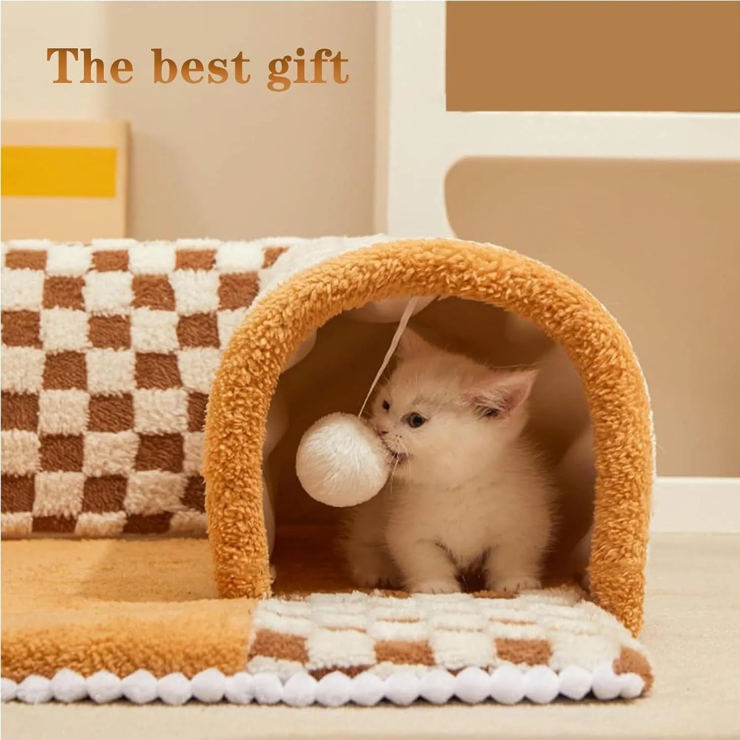 Brown plaid plush cat tunnel bed with a zippered entrance and central mat on a wooden floor.