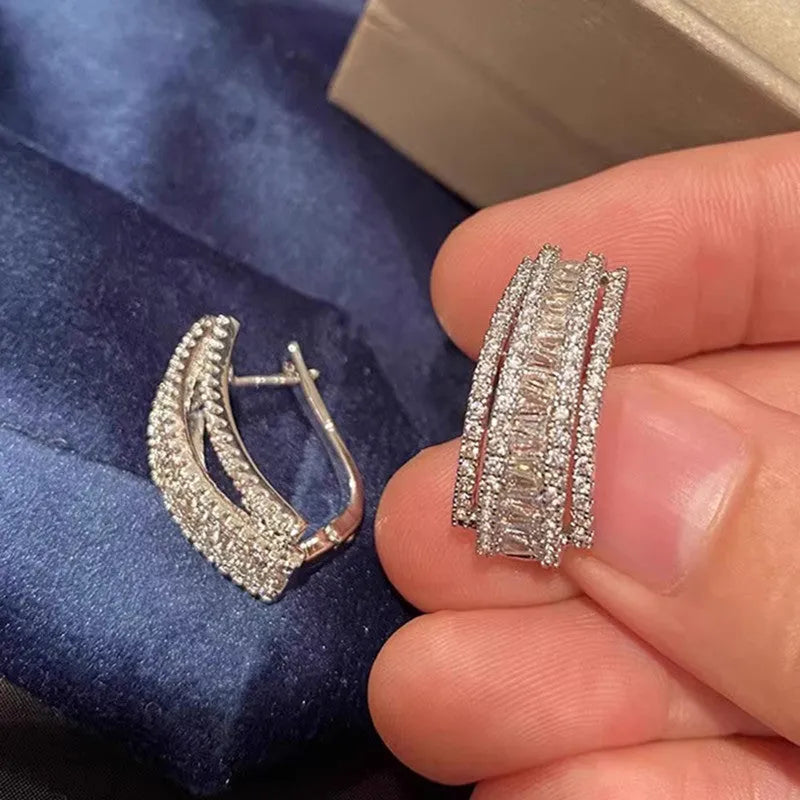 A pair of geometric shaped stud earrings with inlaid zircon stones in a white gold colour finish.