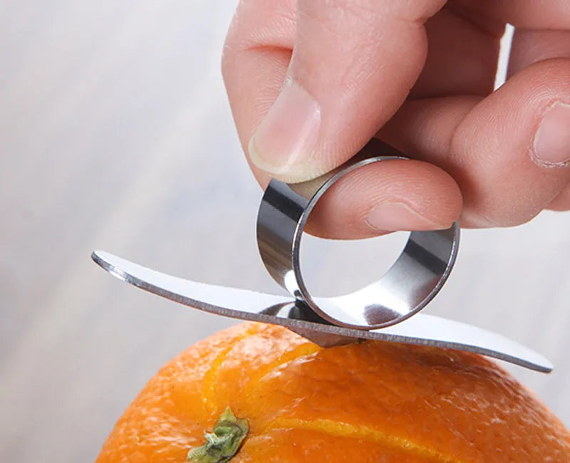 Silver stainless steel orange peeler ring on a citrus fruit