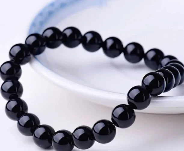 A geometric black agate bead stretch bracelet with 8mm stones on an elastic cord.