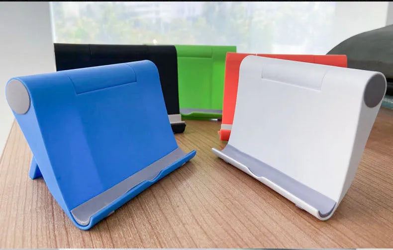 Black PE folding mobile phone stand holding a tablet at an angle on a wooden desk.
