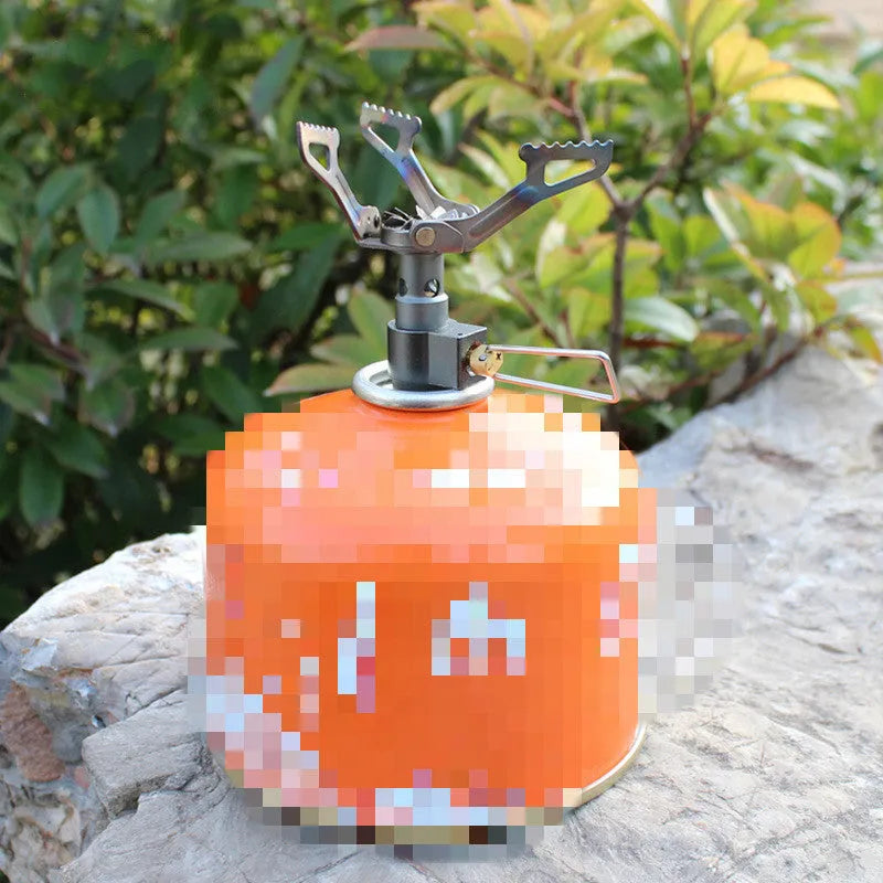 Portable propane camping stove with a one-piece metal furnace body.