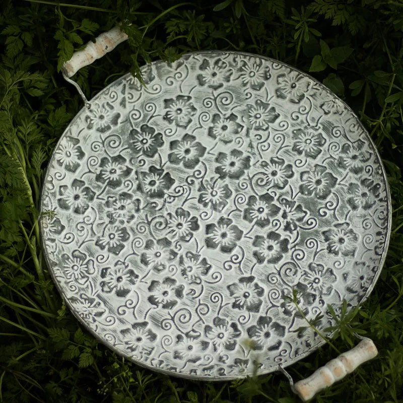 Round wrought iron storage tray in two sizes on a wooden table.
