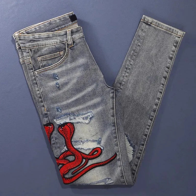Men's slim fit jeans in old colour with a worn look, hole patches, and embroidered details on a mid-waist design.