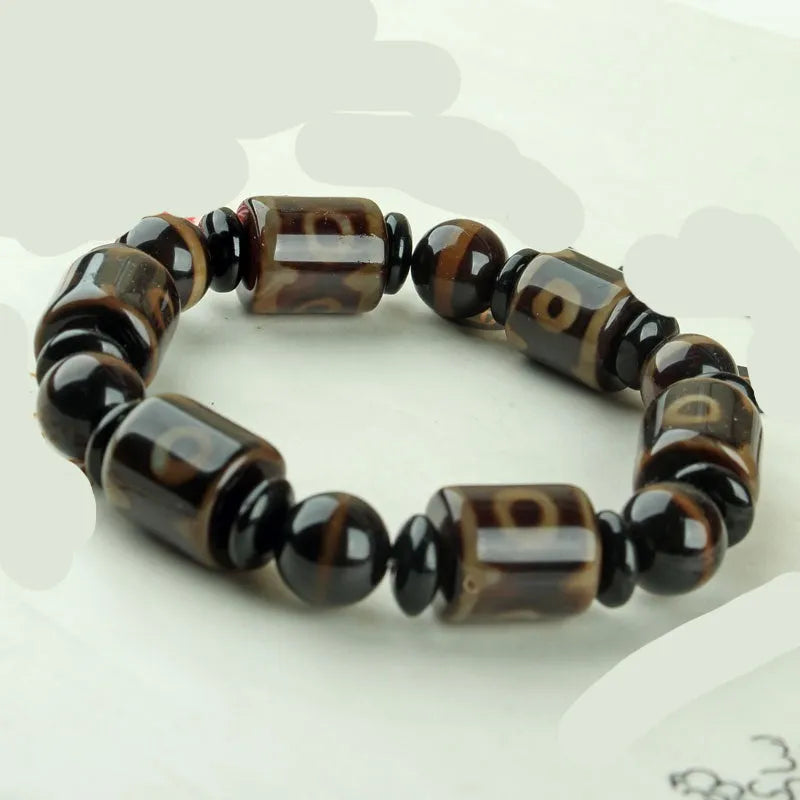 Distressed agate Tibet bead bracelet with three-eye motifs and multiple traditional bead styles on wrist