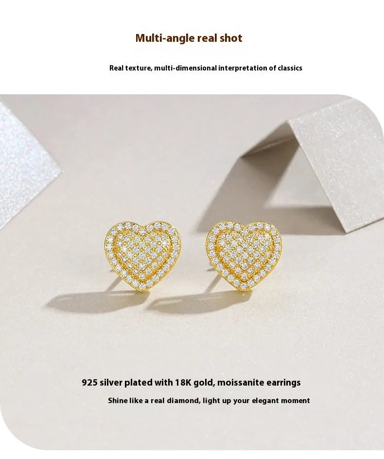 A pair of gold-coloured S925 sterling silver heart stud earrings with moissanite stones.